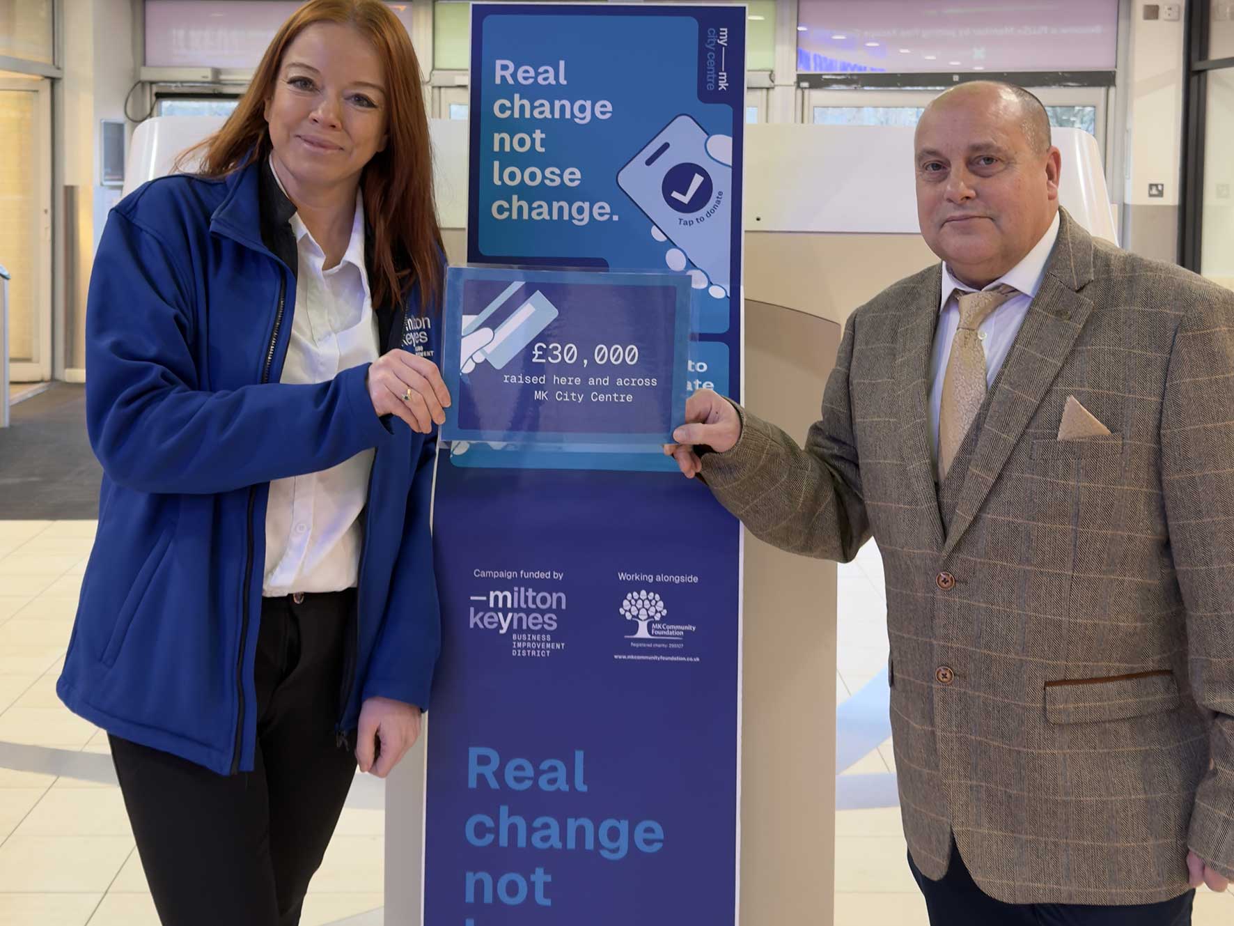 Jill Farnsworth from MyMiltonKeynes stands beside a Tap to Donate machine in Milton Keynes city centre